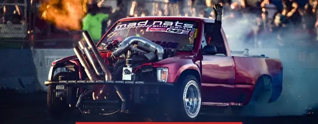 A blown pickup lays down a burnout in thick white tire smoke