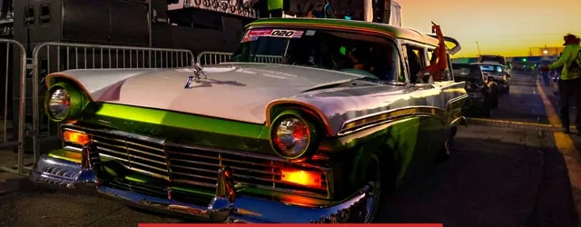 A green two-tone Ford wagon on the cruise route at sunset
